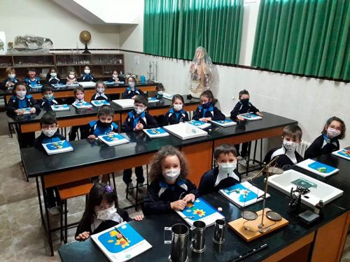 Grupo completo de niños sentados en el aula de ciencias