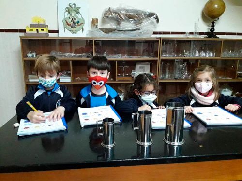 Mesa de trabajo de niños realizando una actividad en el aula de ciencias